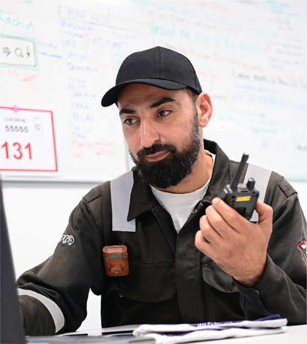 HSE-professional met portofoon bij een planningsbord